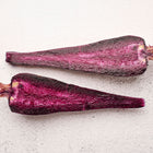Two halves of a Black Nebula carrot showing deep purple-black flesh on a textured white background.