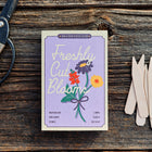 Freshly Cut Blooms seed collection box with wooden markers and vintage shears on a rustic wooden surface.