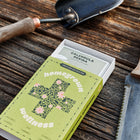 Homegrown Wellness seed kit box showing Resina Calendula packet on a wooden surface with gardening tools.