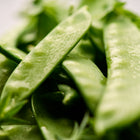 Close-up of fresh, flat Oregon Sugar Pod II snow pea pods with a vibrant green color and crisp texture.