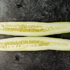 Two halves of a sliced Suyo Long cucumber showing light green flesh and seeds on a dark textured background.