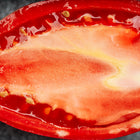 Cross-section of a bright red Amish Paste tomato showing its meaty, low-seed interior texture.